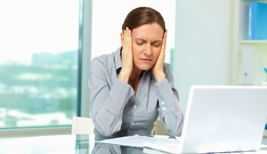 Image of annoyed businesswoman in front of laptop in office